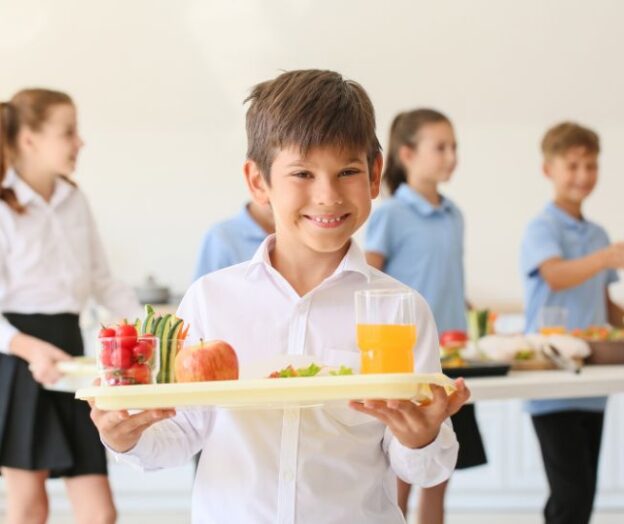 School boy holding tray of food